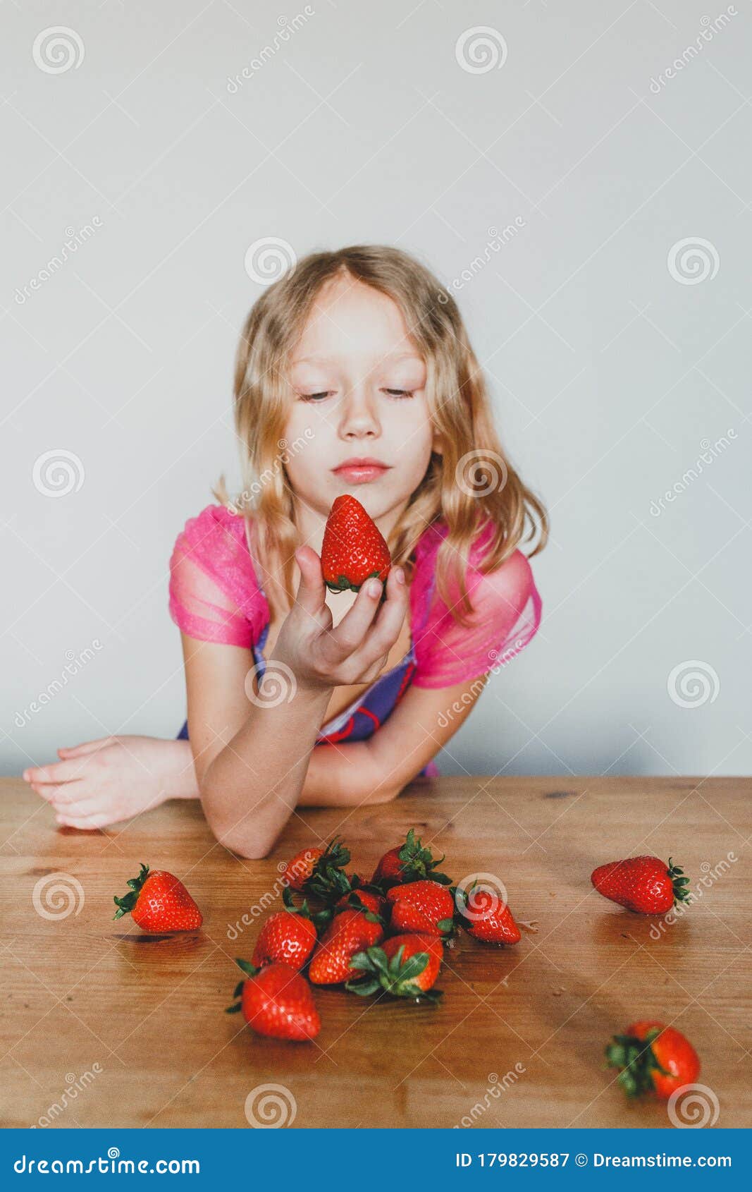 Cute European Girl Eating Strawberries A Beautiful Cheerful Blonde With Blue Eyes Stock Image 