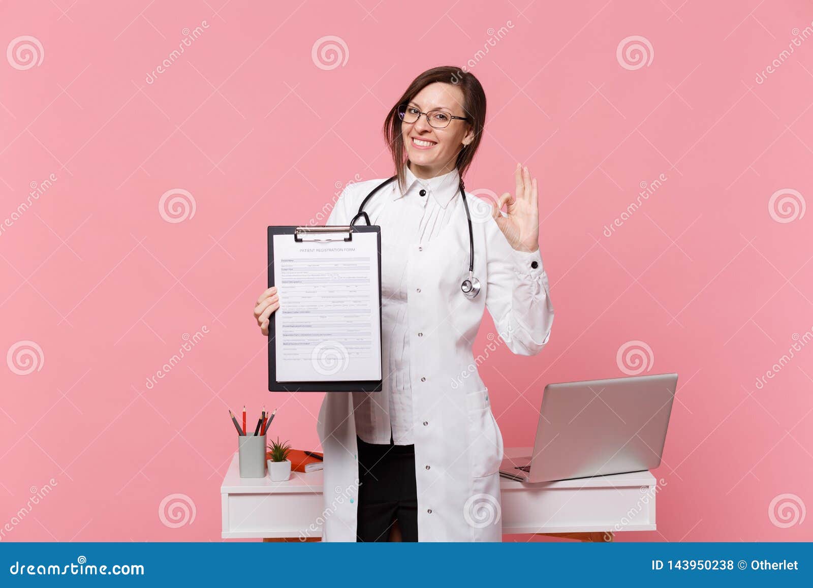 Cute Female Doctor Stand In Front Of Desk With Pc Computer