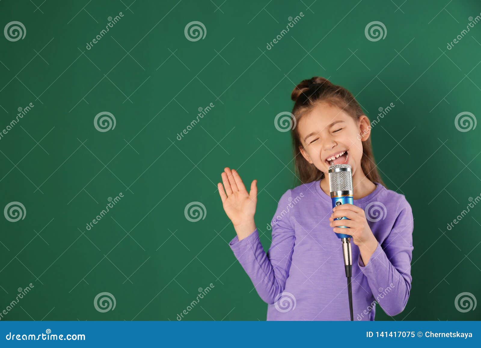 Cute Funny Girl with Microphone on Color Background. Stock Image