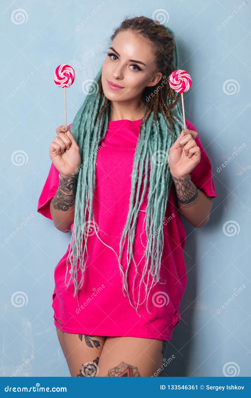 Cute Girl In Pink T Shirt With Dreadlocks And Tattoo Holding