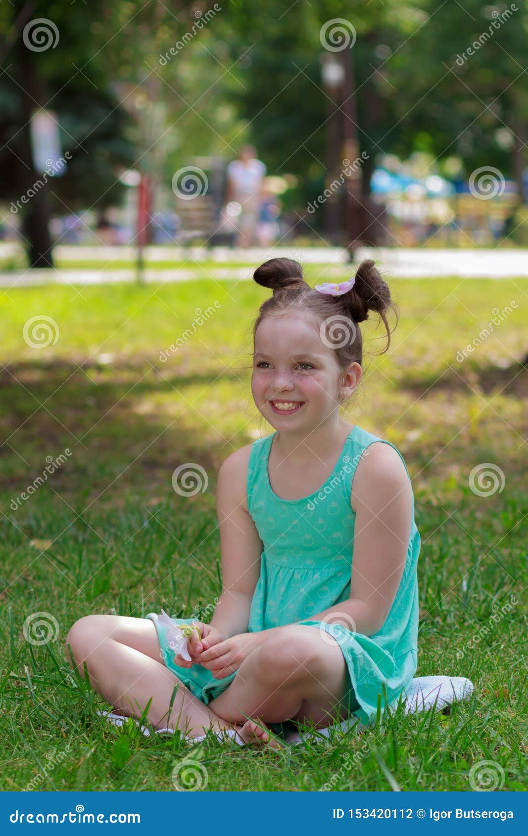 Cute Girl Sits on the Green Grass, Outdoors, Summer Time, Blurred ...