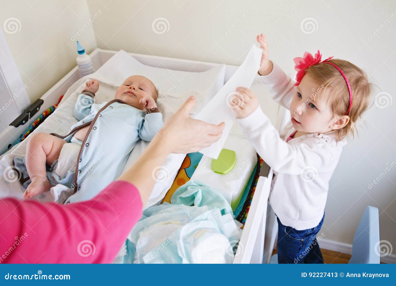 Cute Girl Toddler Helping Her Mother, Changing Baby Diaper Stock Image