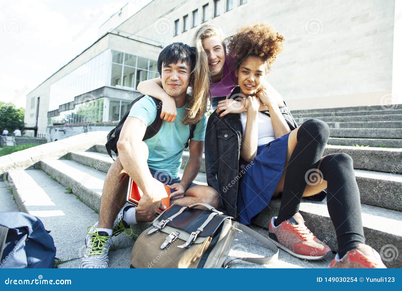 cute group of teenages at the building of university with books huggings, diversity nations students lifestyle