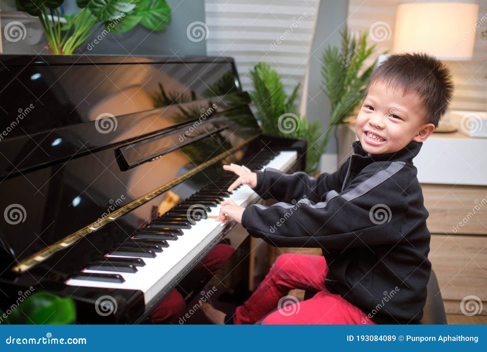 Cute Happy Smiling Little Asian Kid Boy Playing Piano in Living Room