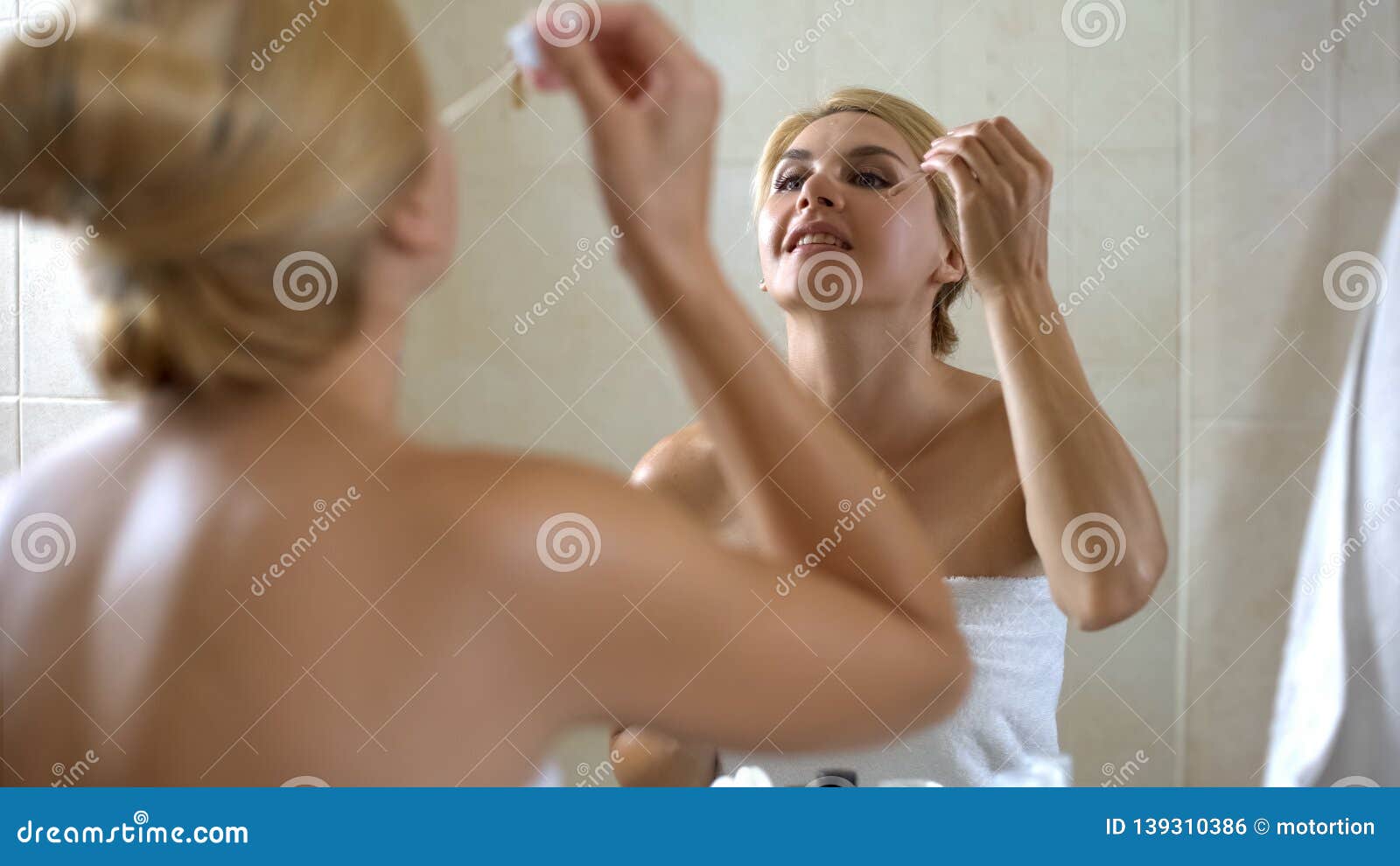 cute lady applies face moisturizer on dry sensitive skin, cosmetology at home