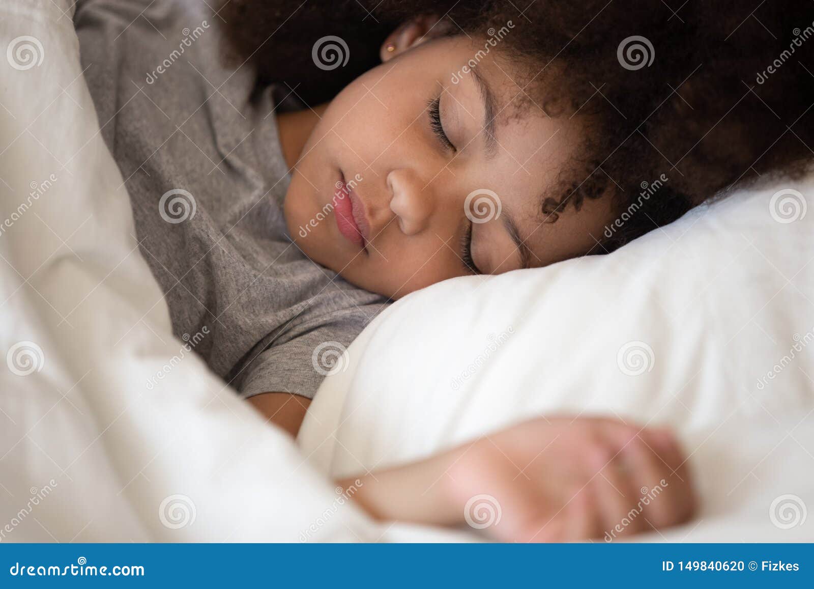 cute little african american kid girl sleeping alone in bed