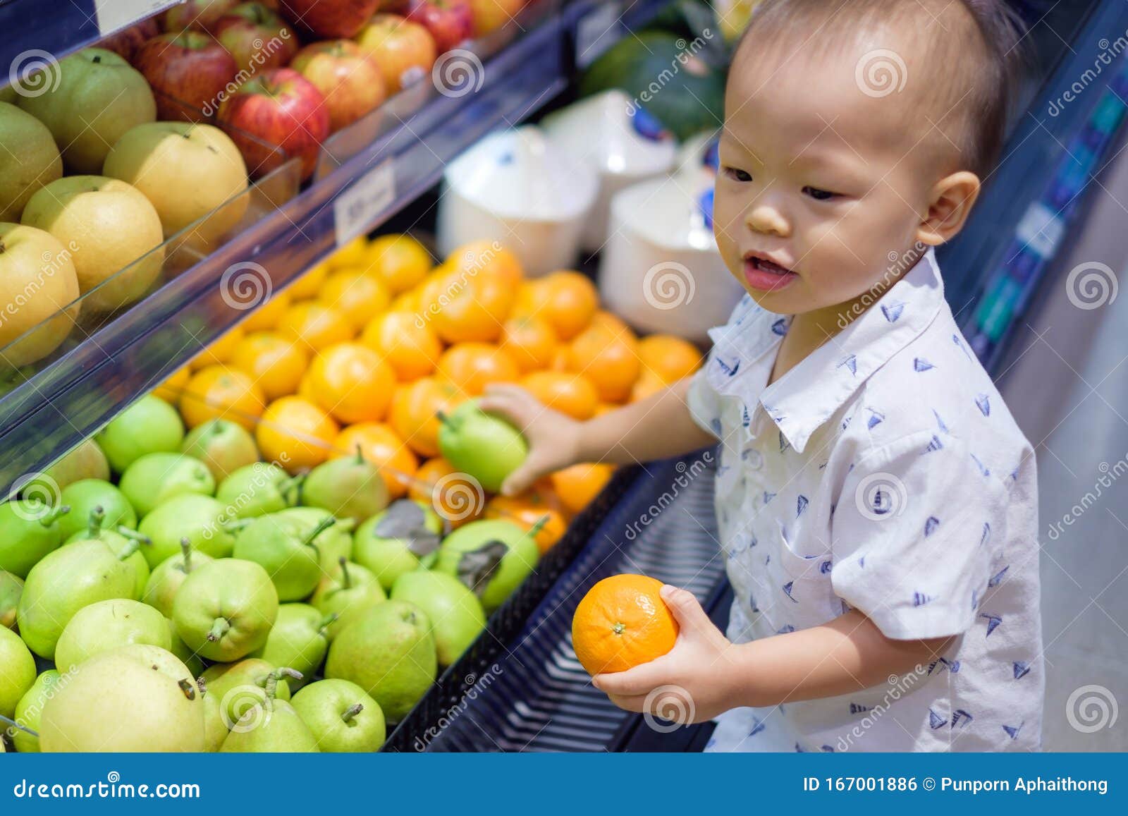 cute little asian 18 months / 1 year old toddler baby boy child shopping in a supermarket