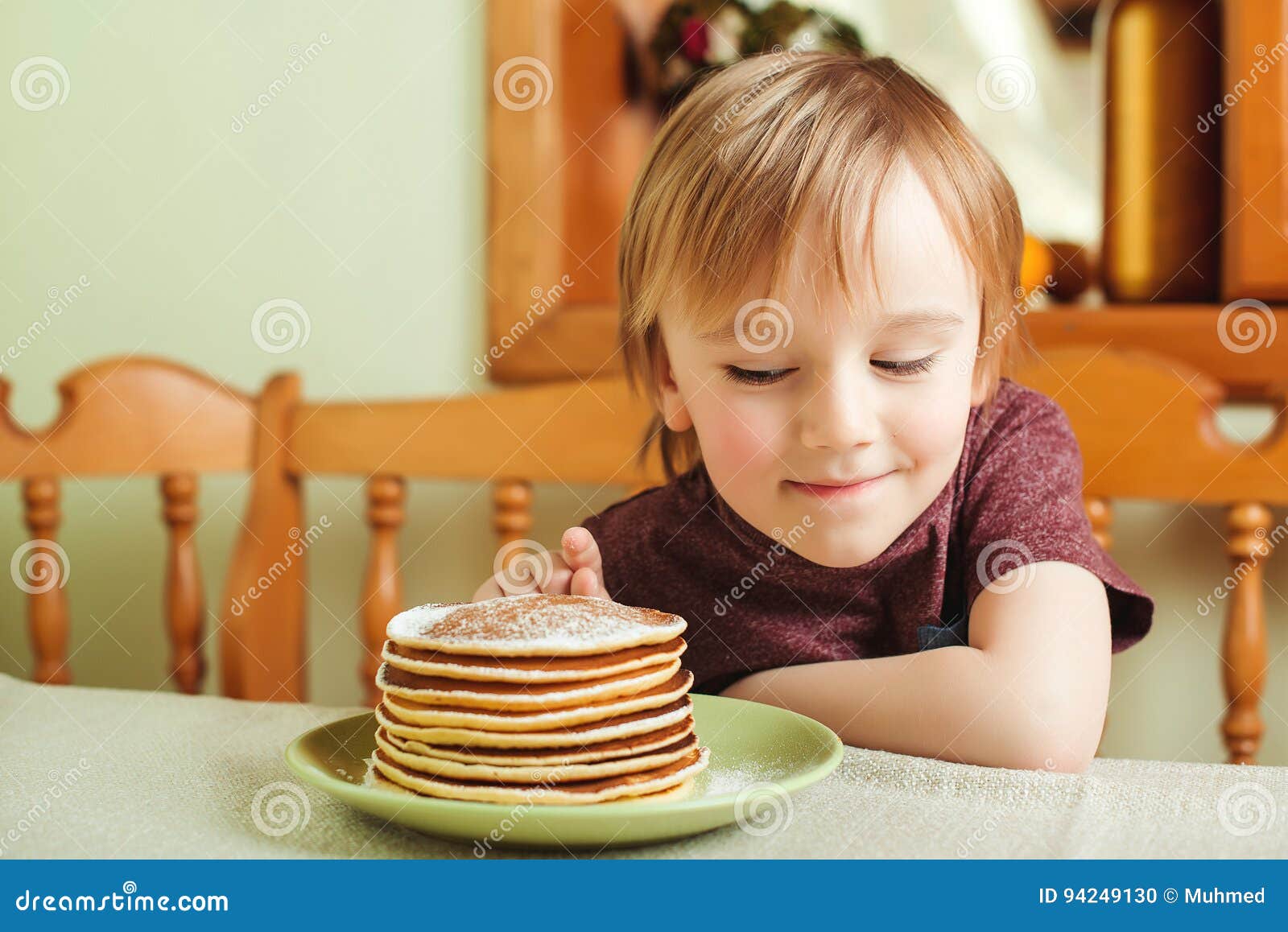 Cute Little Boy Eating a Stack of Pancakes in the Kitchen. Stock Photo ...