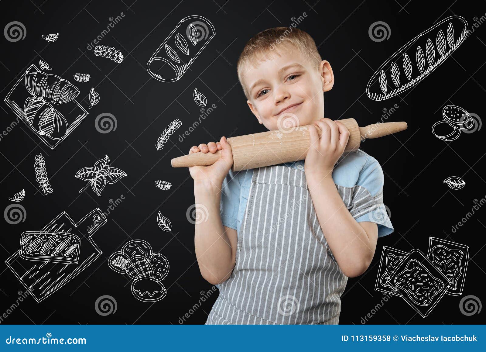 cute little child smiling cheerfully while standing with a rolling pin