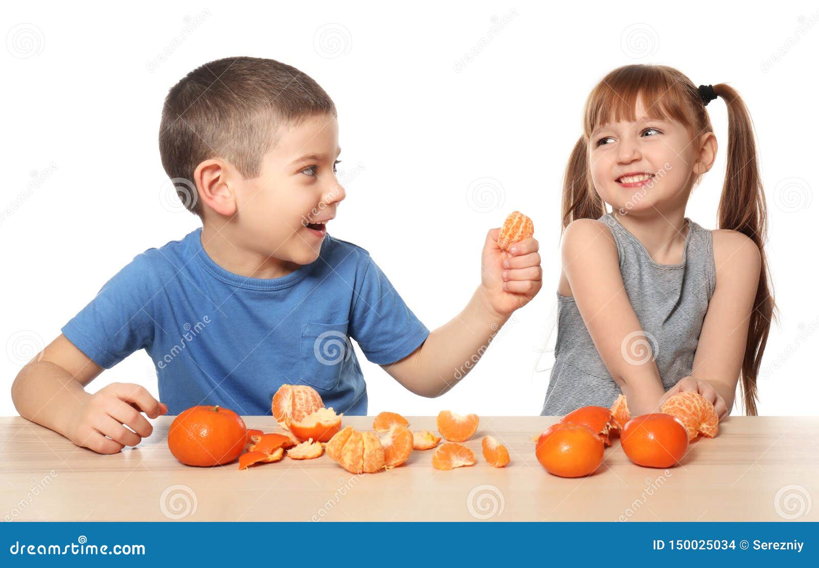 Cute Little Children Eating Citrus Fruit at Table on White Background