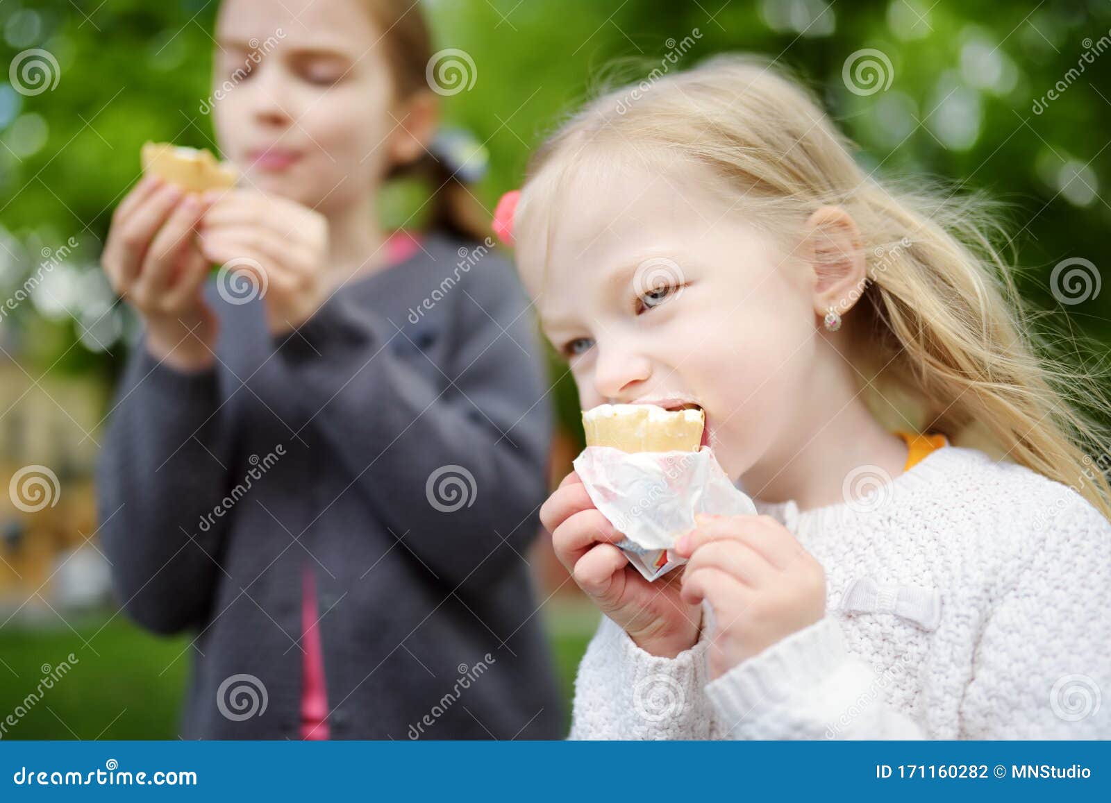 Cute Little Children Eating Tasty Fresh Ice Cream in Outdoor Cafe. Kids