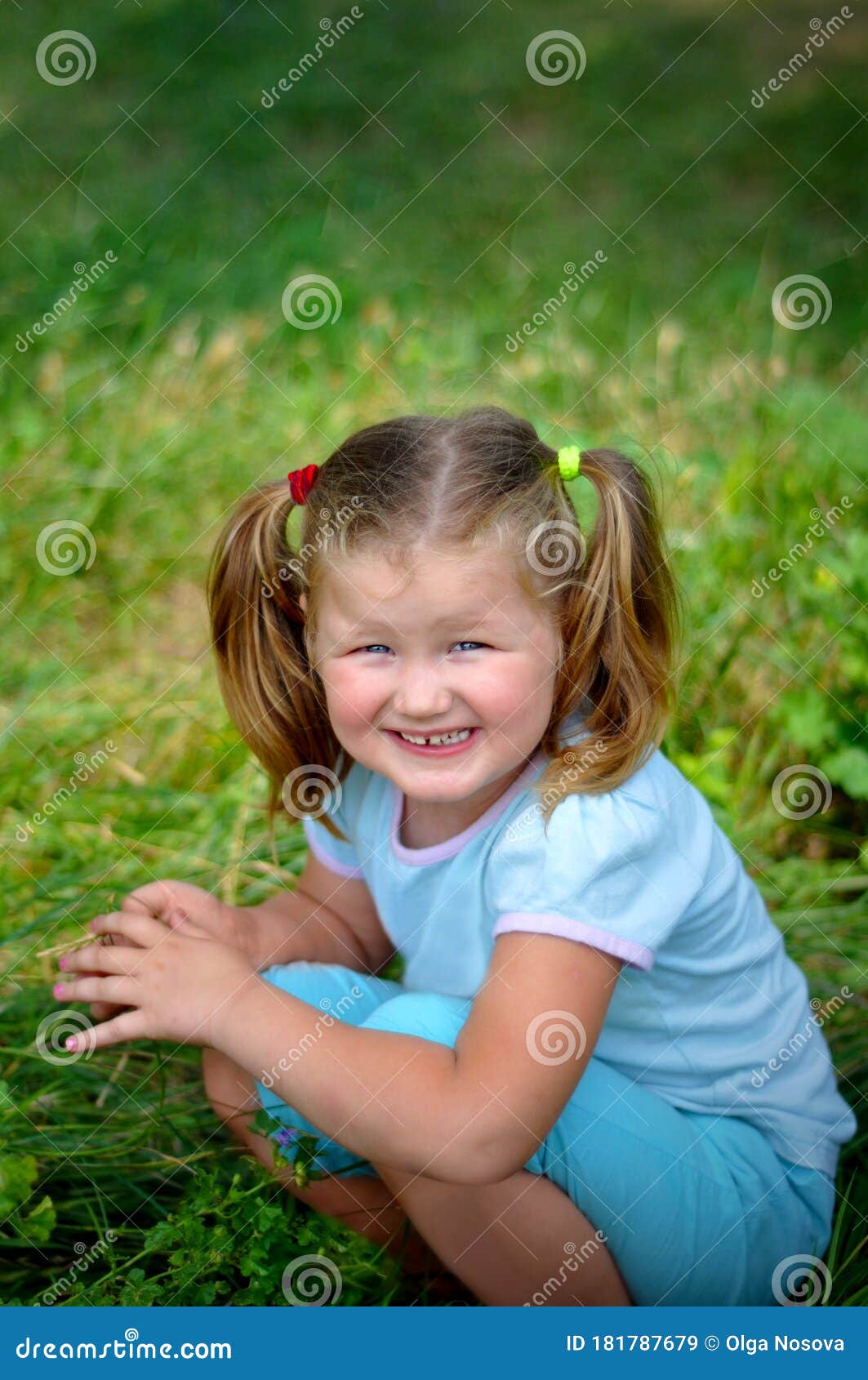 Cute Little Girl with Bow Tails Sit and Smile on the Green Meadow Grass ...