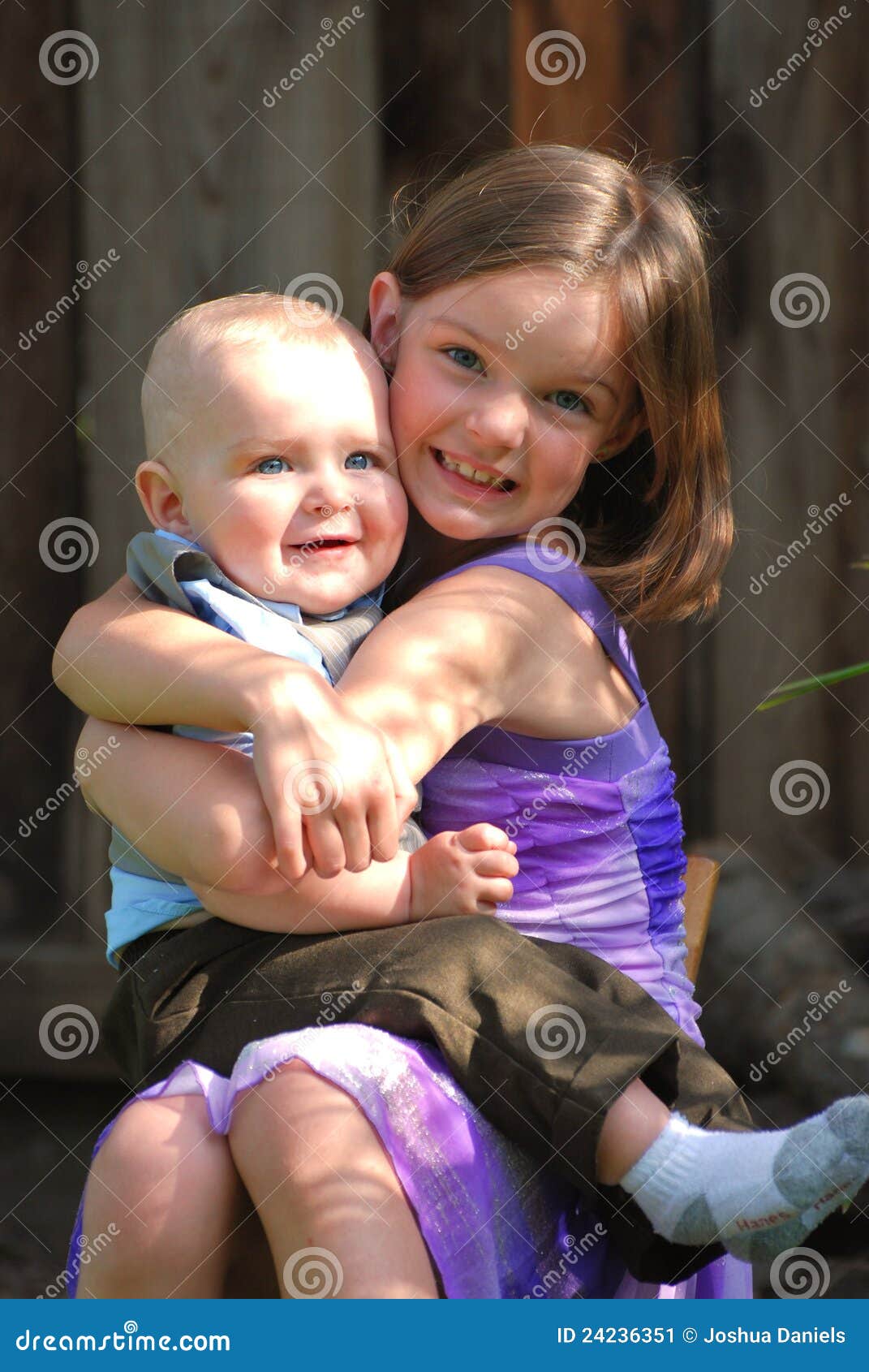 cute little girl holds baby boy smiles 24236351