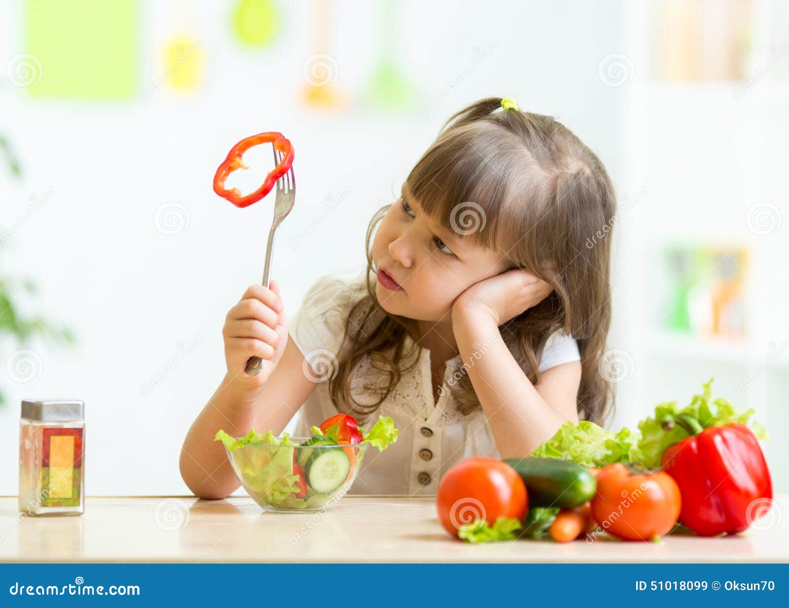 cute little girl not wanting to eat healthy food