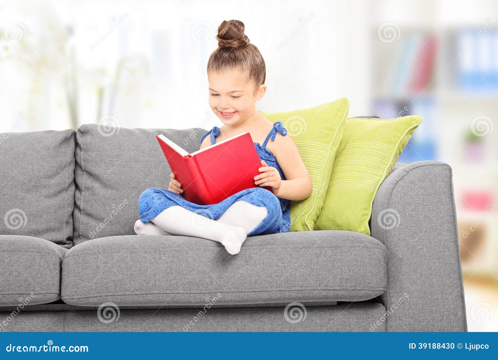 Cute Little Girl Reading A Book In The Living Room Stock 