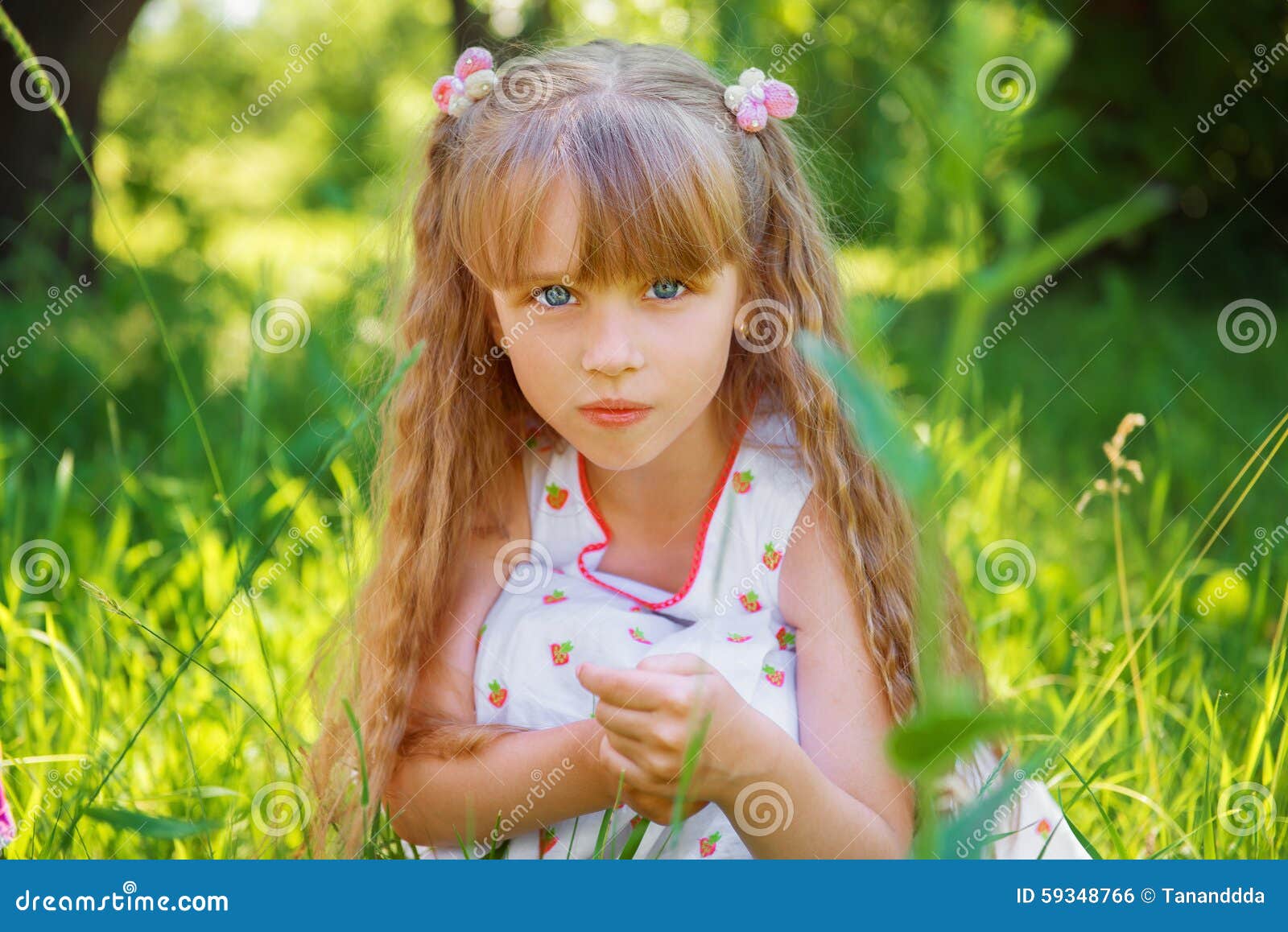 Cute Little Girl Sitting On The Grass On Stock Photo - Image: 59348766