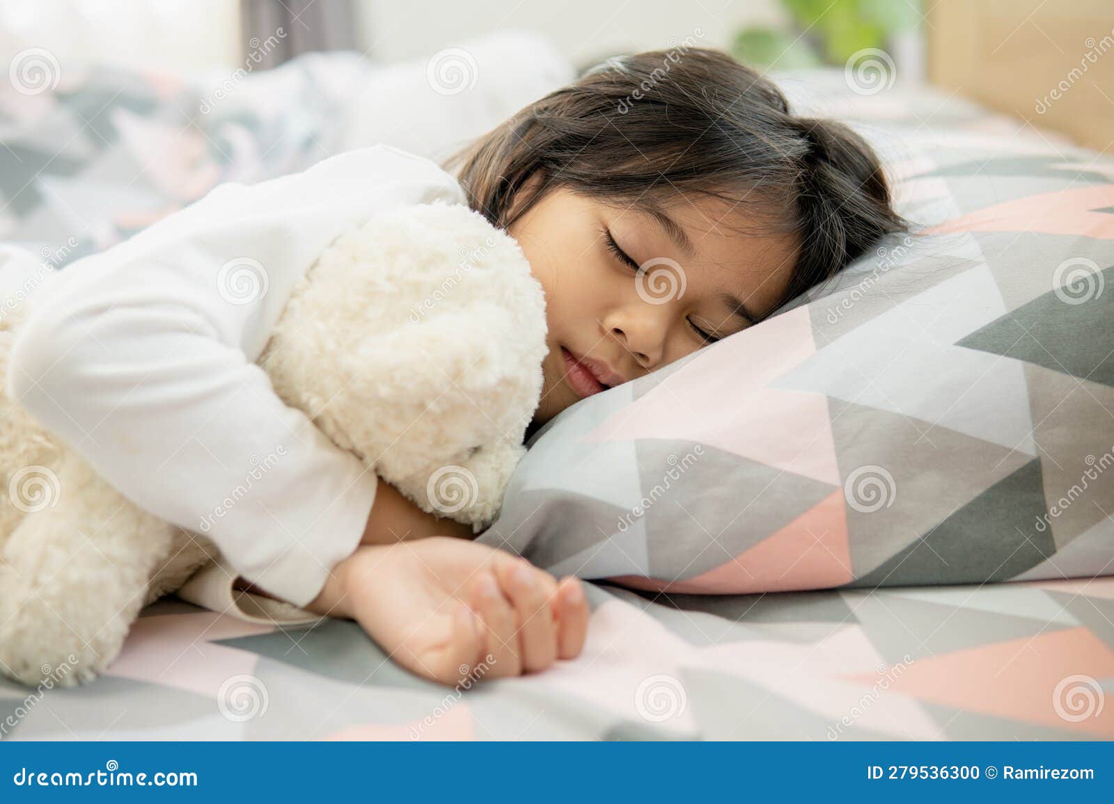 Cute Little Girl Sleeping on Bed with Soft Pillows at Home Stock Photo