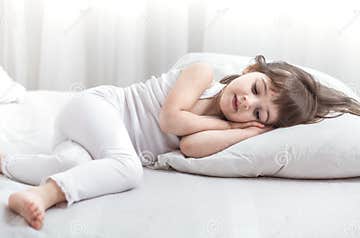 Cute Little Girl Smiling while Lying in a Cozy White Bed Stock Image ...