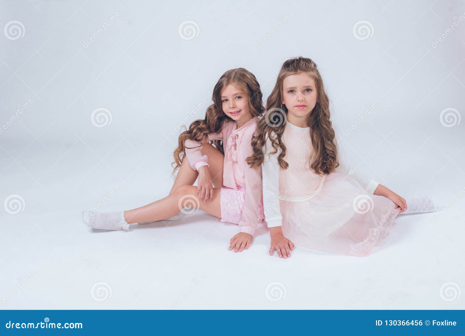 Cute Little Girls With Curly Hair In Fashionable Clothes Of