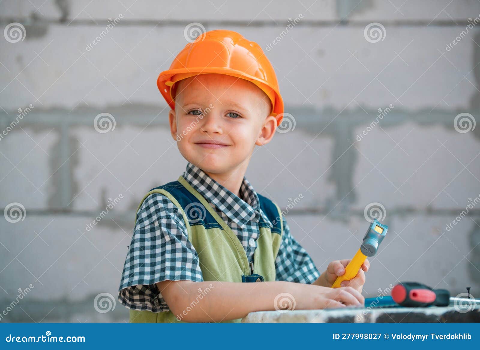 Cute Little Kid in Builder Helmet with Repair Tools on Construction