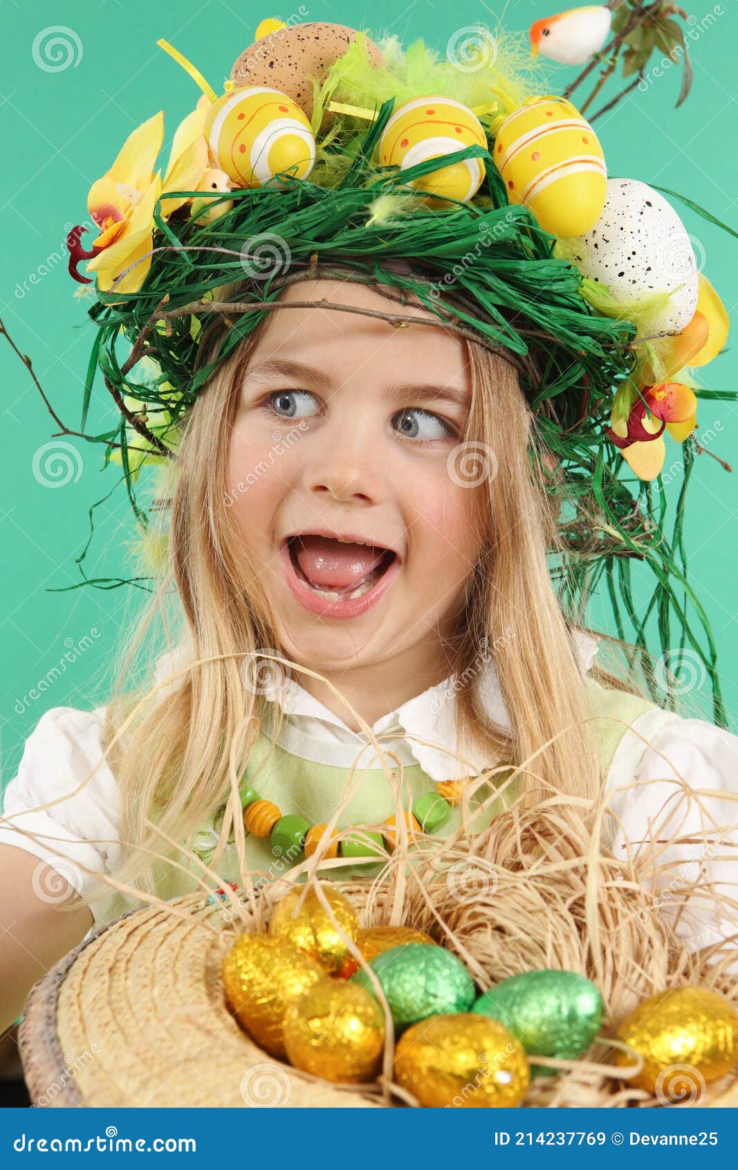 Cute little child wearing a fun hairstyle on Easter Day. Girl with basket  of shiny eggs looks at an easter egg squinting Stock Photo - Alamy