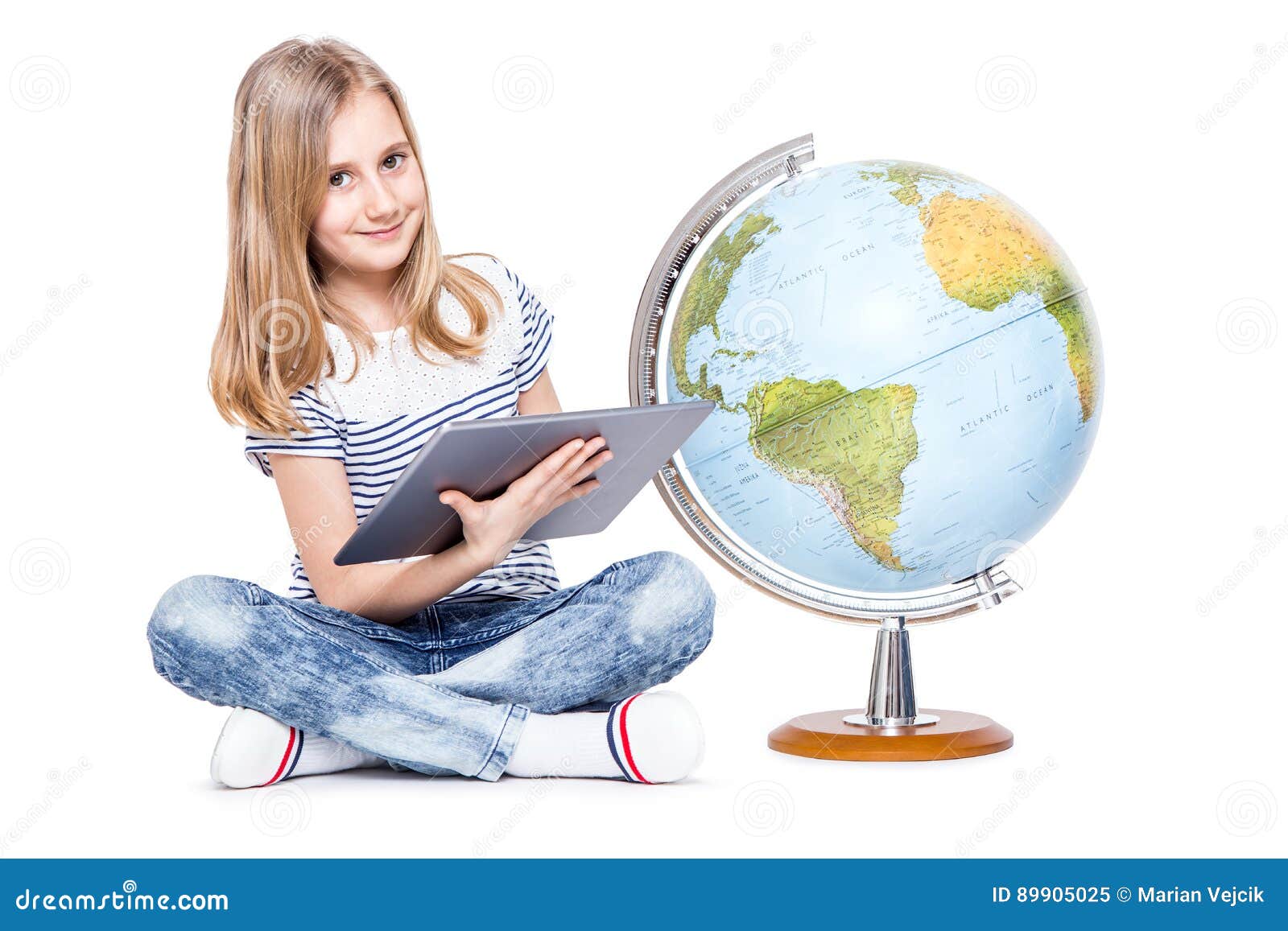 cute little young girl with tablet and globe. schoolgirl using modern technology in teaching geography