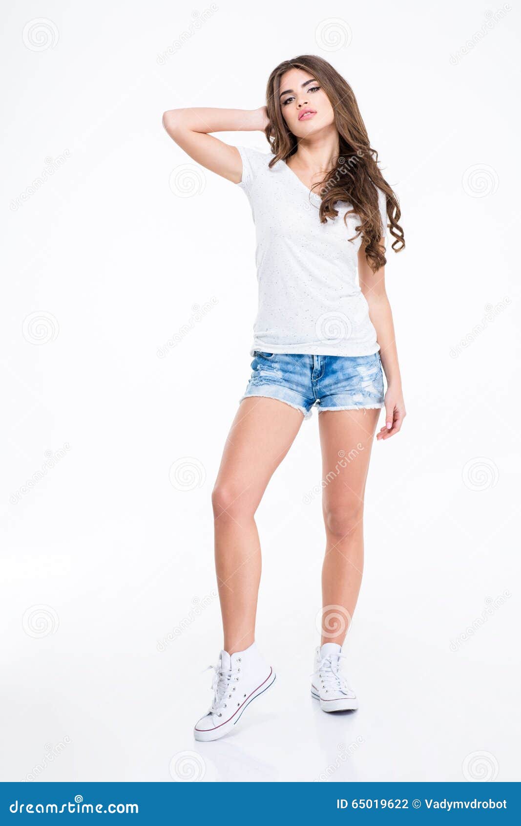 Young Pretty Woman In Short Jeans Standing On White Background