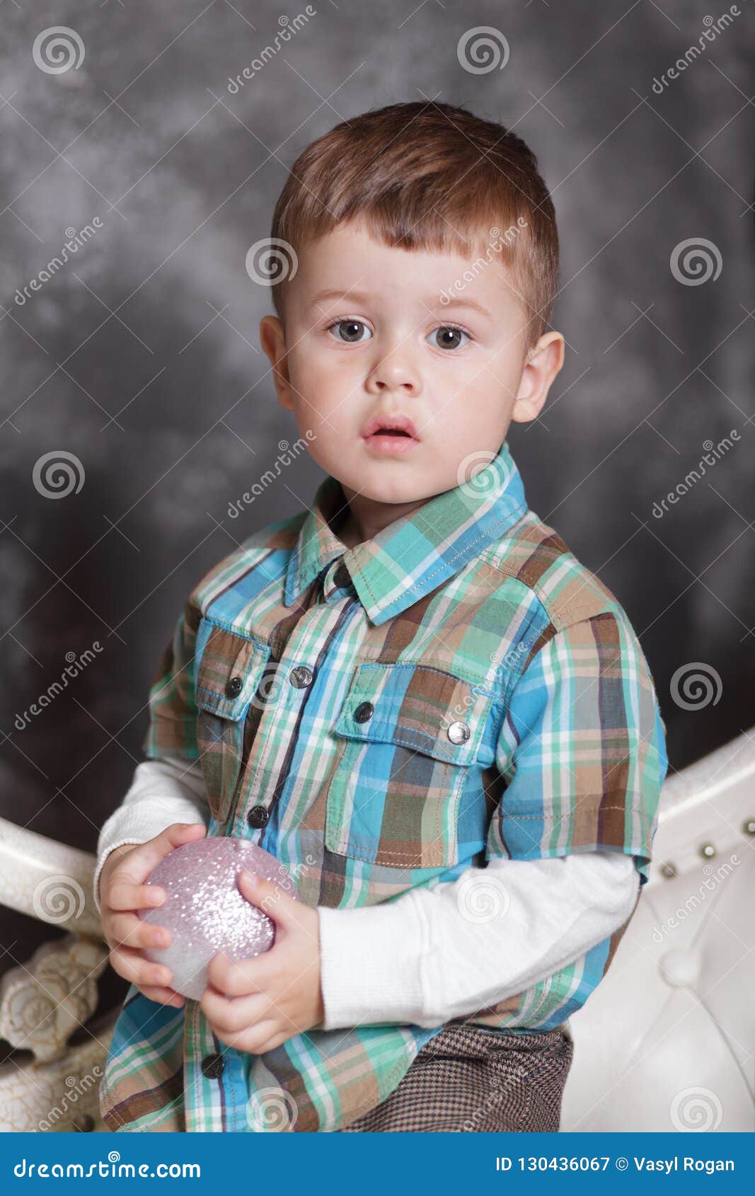 cute portrait of little boy celebrates christmas. boy playing decoraction ball.