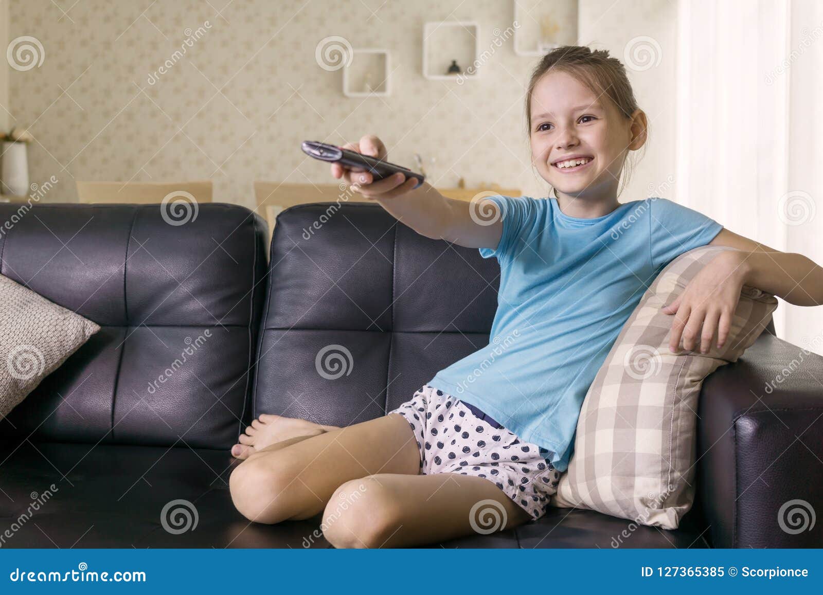 Cute Preteen Girl Watching TV On Couch Using Remote Control Living