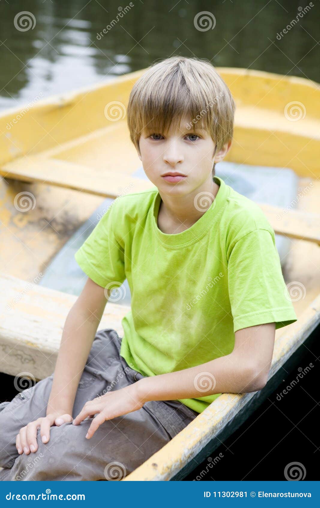 cute serious boy sitting in boat stock image - image of