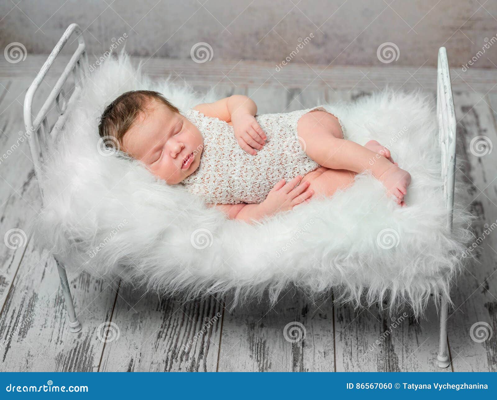 Cute Sleeping Newborn Baby on Cot with Fluffy Blanket Stock Photo