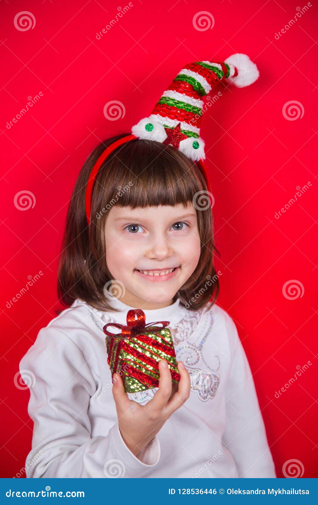 Cute Smiling Little Girl In Elf Hat Holding Festive Gift Box