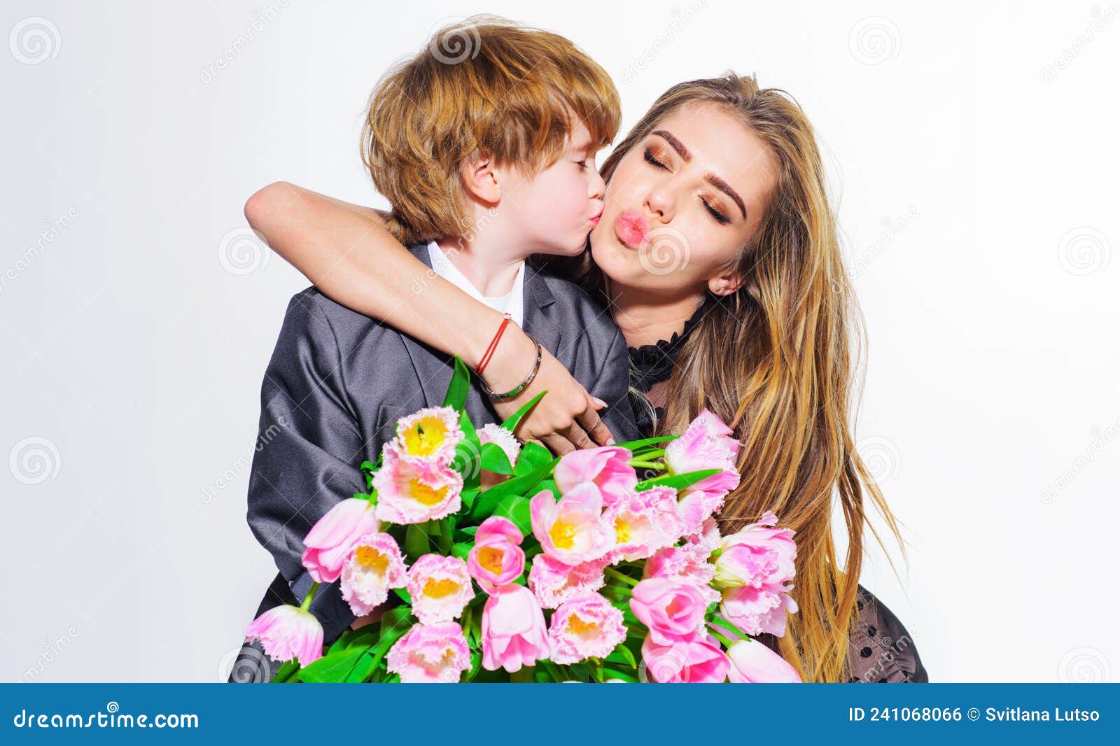 Cute Son Congratulating Mother With Bouquet Of Tulips On Womens Day