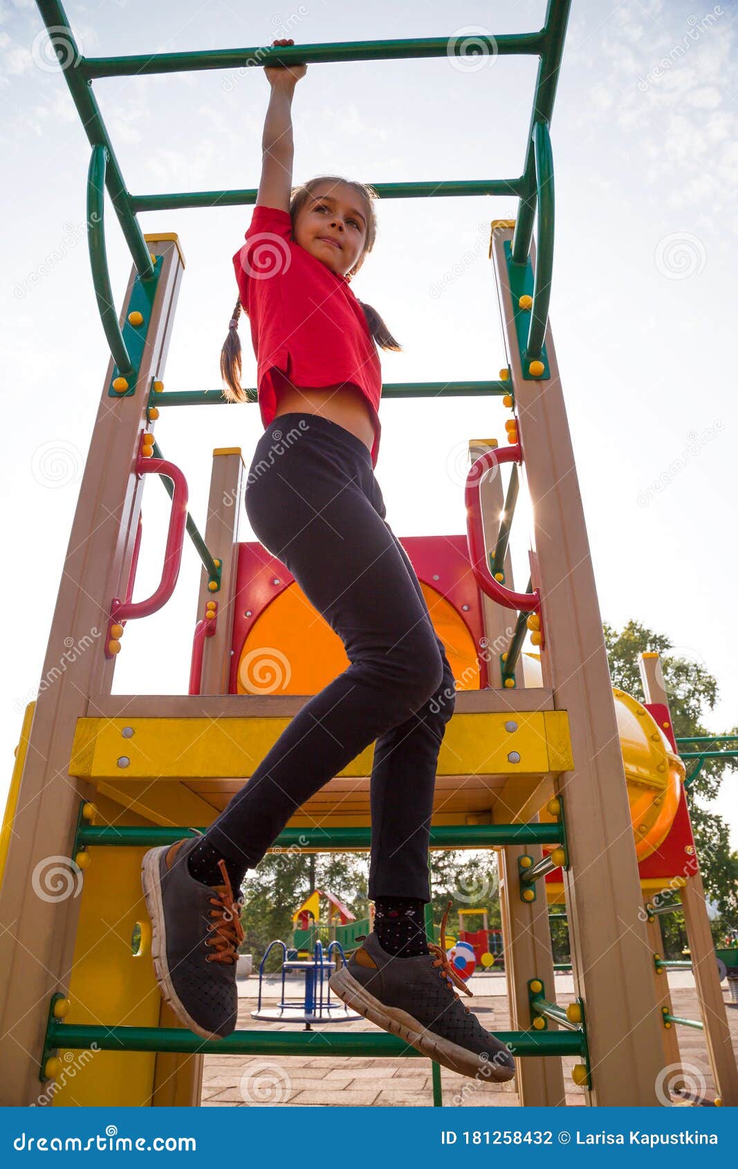 Girls in the park playing on monkey bars Stock Photo - Alamy
