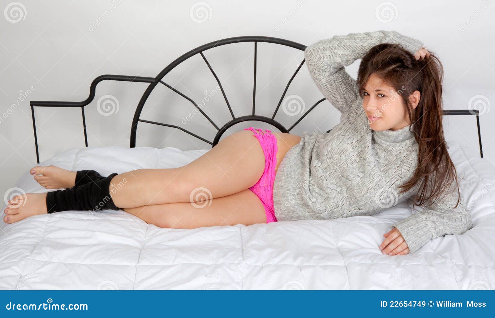 Cute Woman in Leg Warmers and Pink Panties on Bed Stock Image