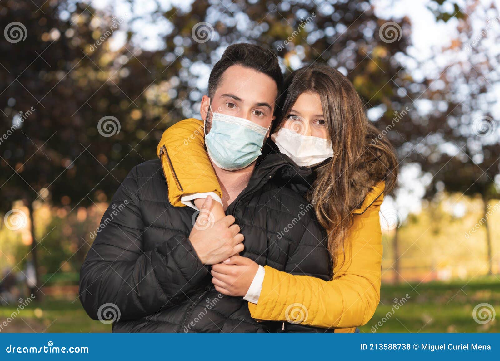 Cute Young Couple Wearing Face Masks and Hugging Each Other in a Park ...