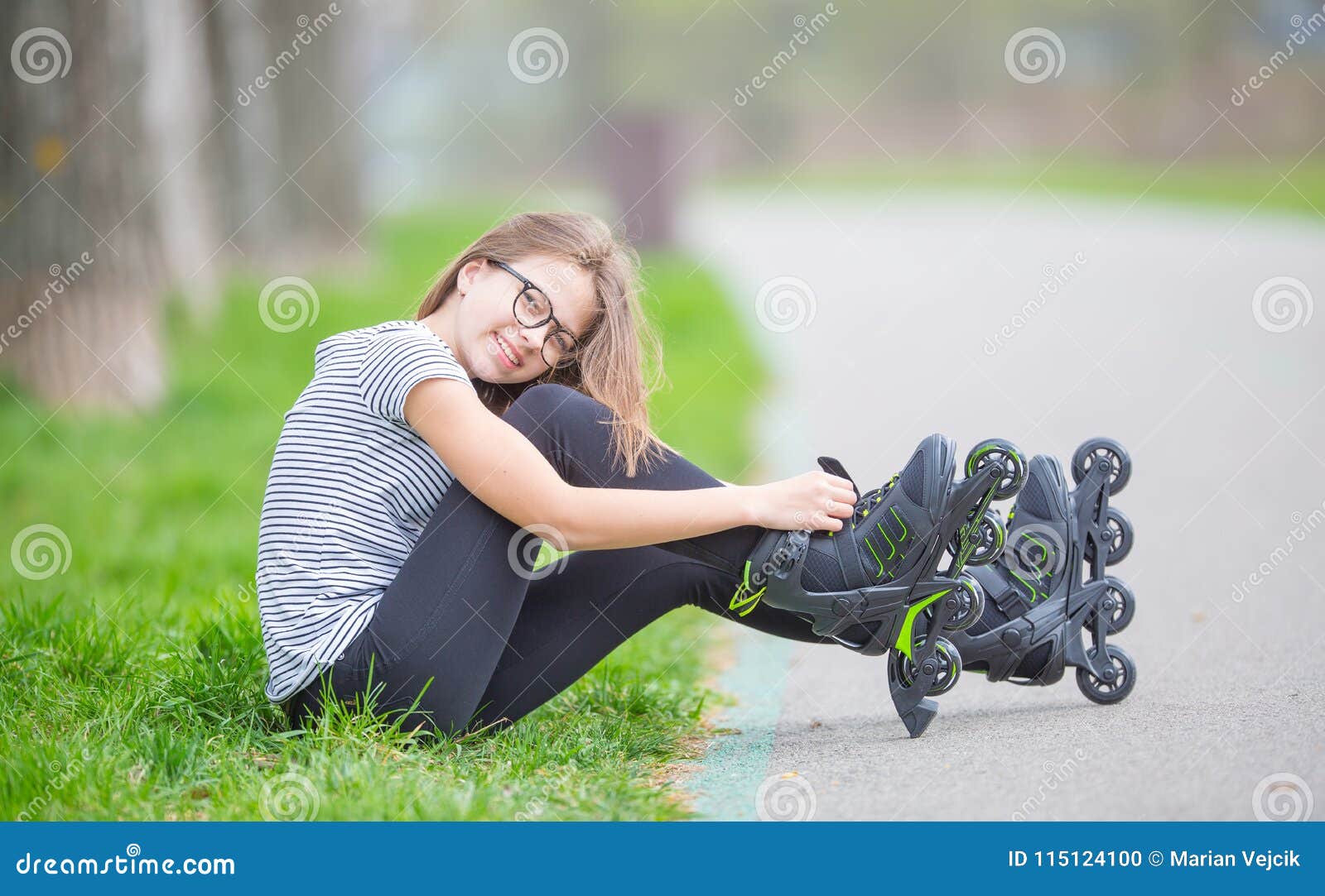 Cute Young Going Rollerblading Sitting in Grass Putting on Inline