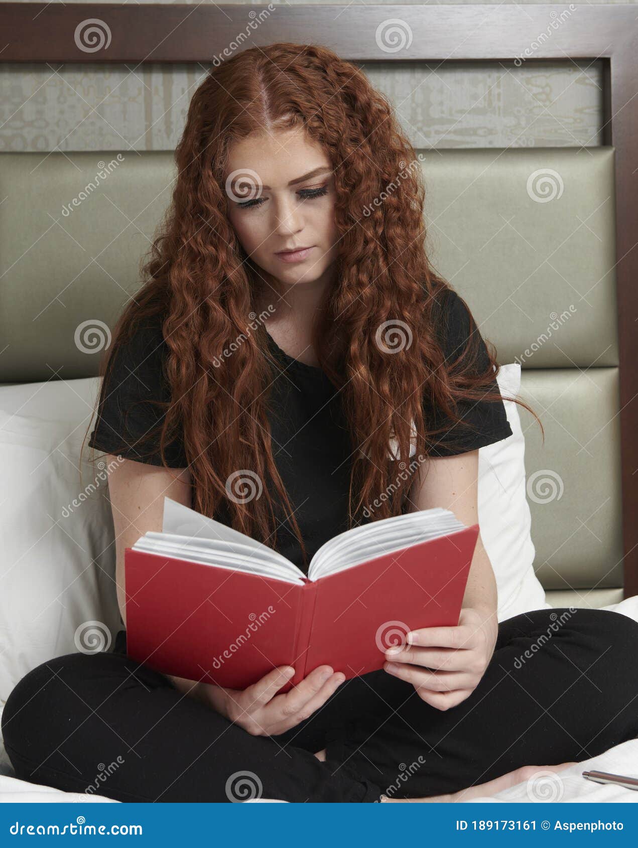 Young redhead woman covered by a book - a Royalty Free Stock Photo