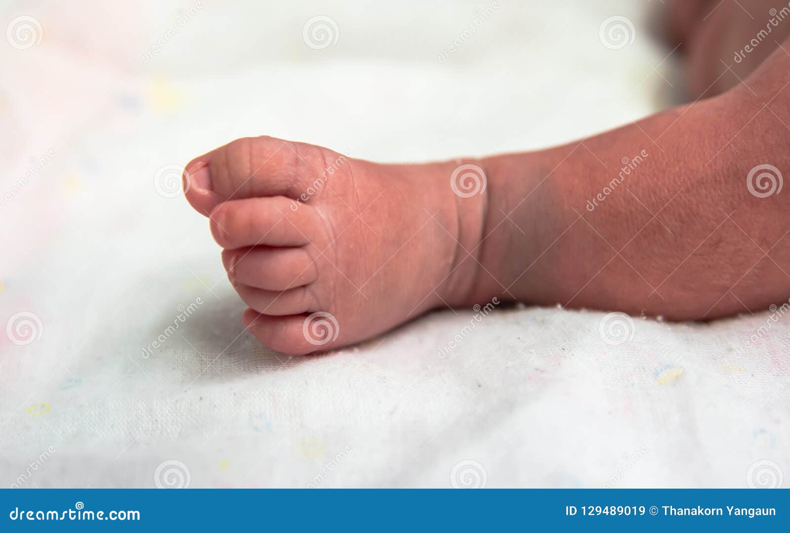 cutes foot of newborn baby in postpartum care unit in hospital when she sleeping with her mother .