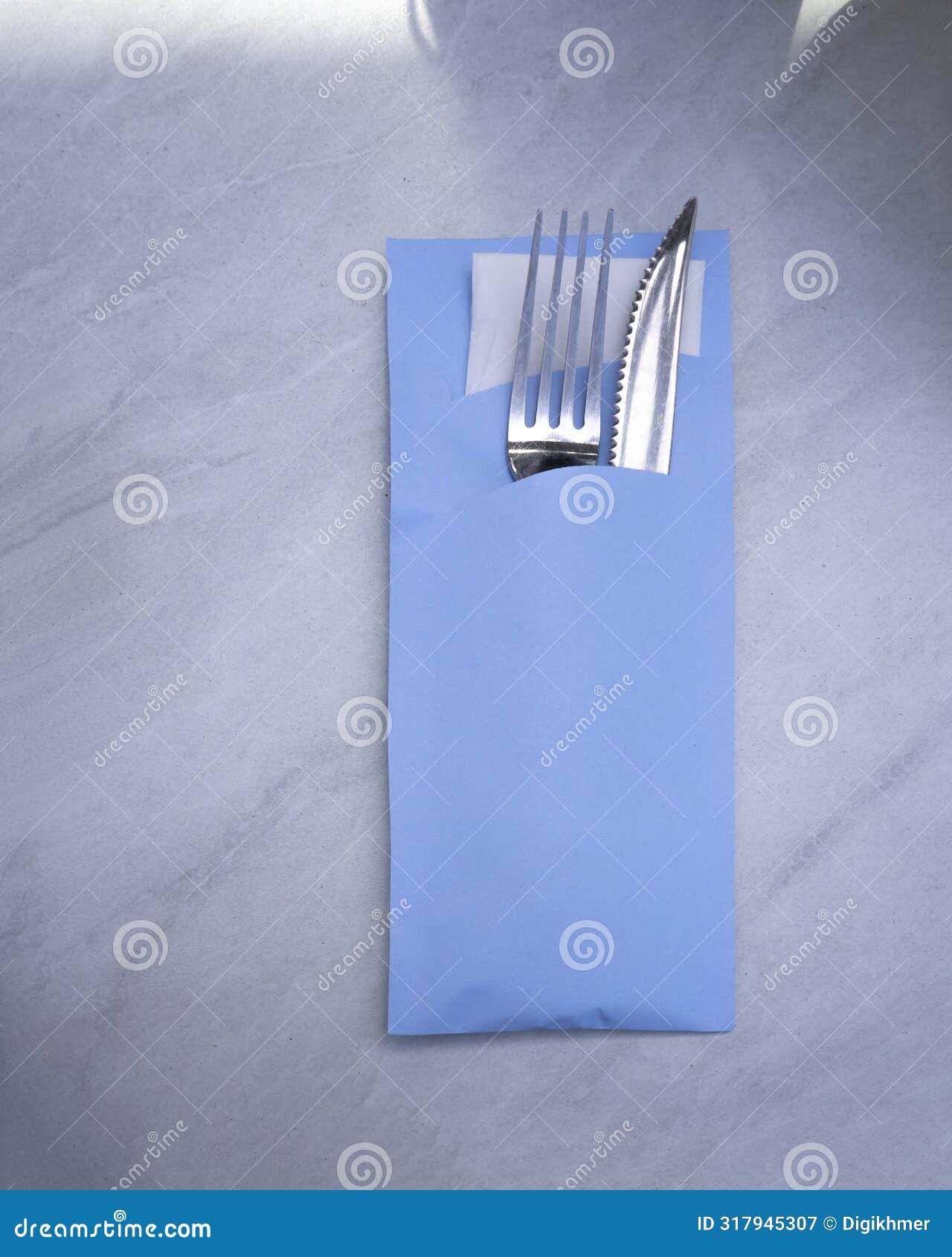 cutlery set with fork, knife, and tissue wrapped inside a blue paper envelope