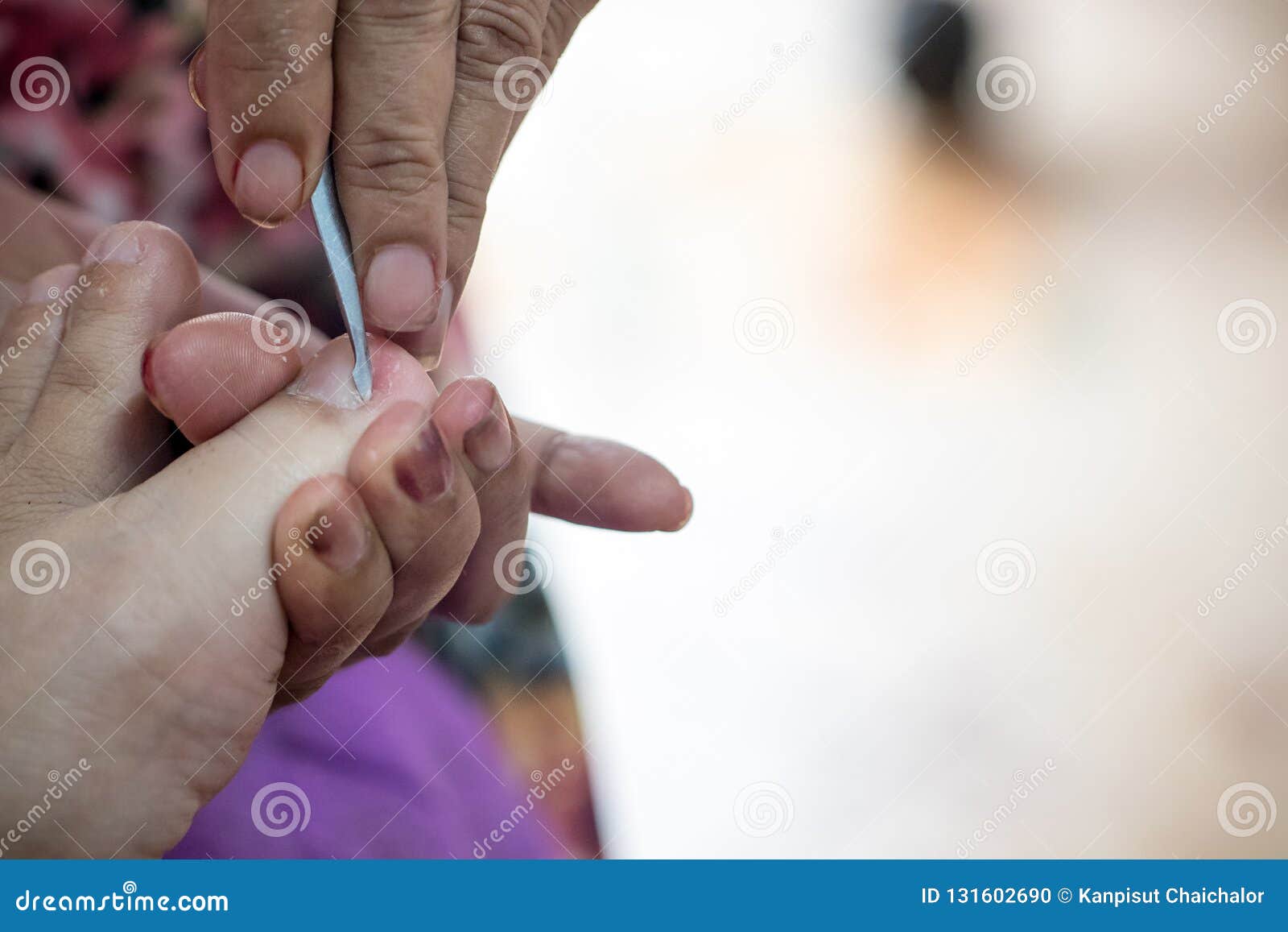 Premium Photo | The manicurist removes the base coat from the nail with an  orange stick during the manicure procedure at the spa
