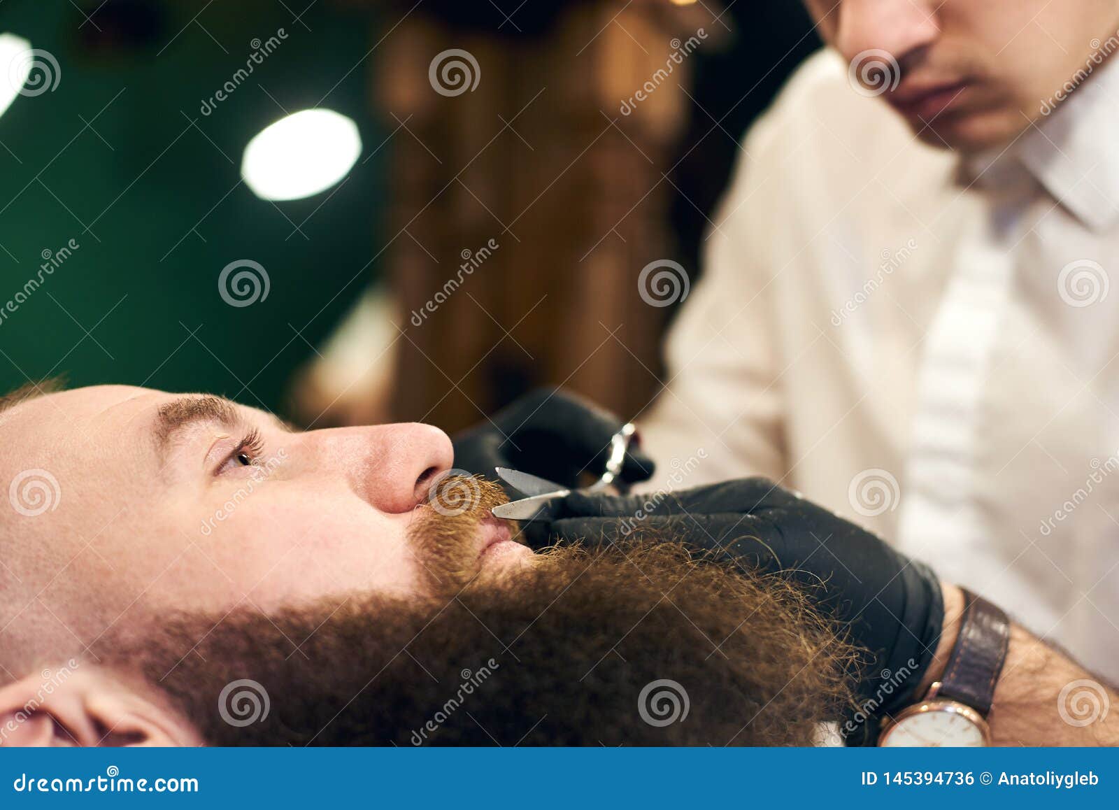 Male Client with Beard Sitting in Hairdresser Chair. Serious Man with