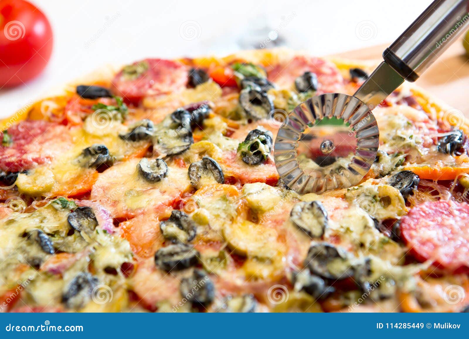 Cutting Pepperoni Pizza on Slices with Special Hand Holding Knife Stock