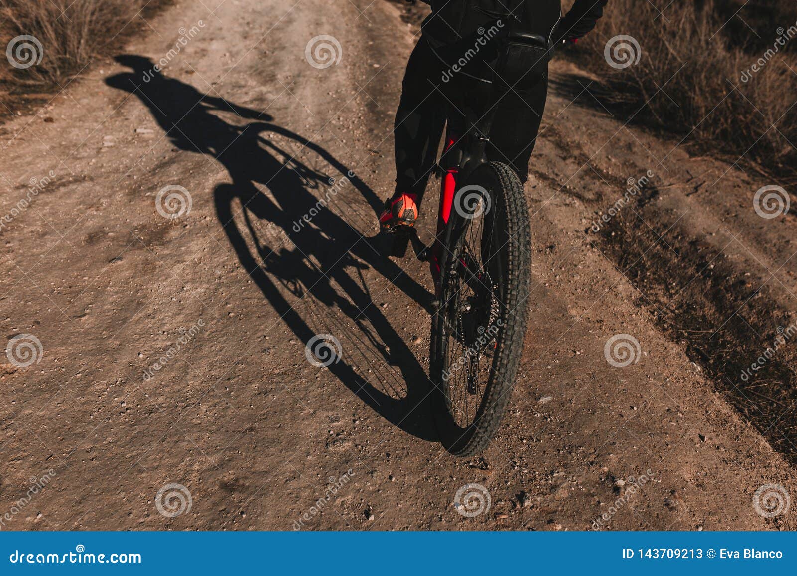 cyclist riding the bike down rocky hill at sunset. extreme sport concept