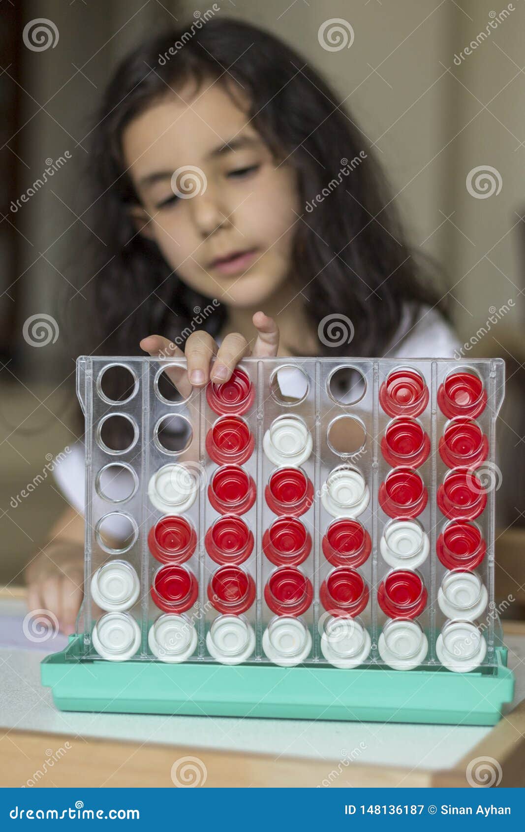 The black hair girl playing with boardgame. Czarni w?osy dziewczyny sztuka z jej boardgame samotnym w domu