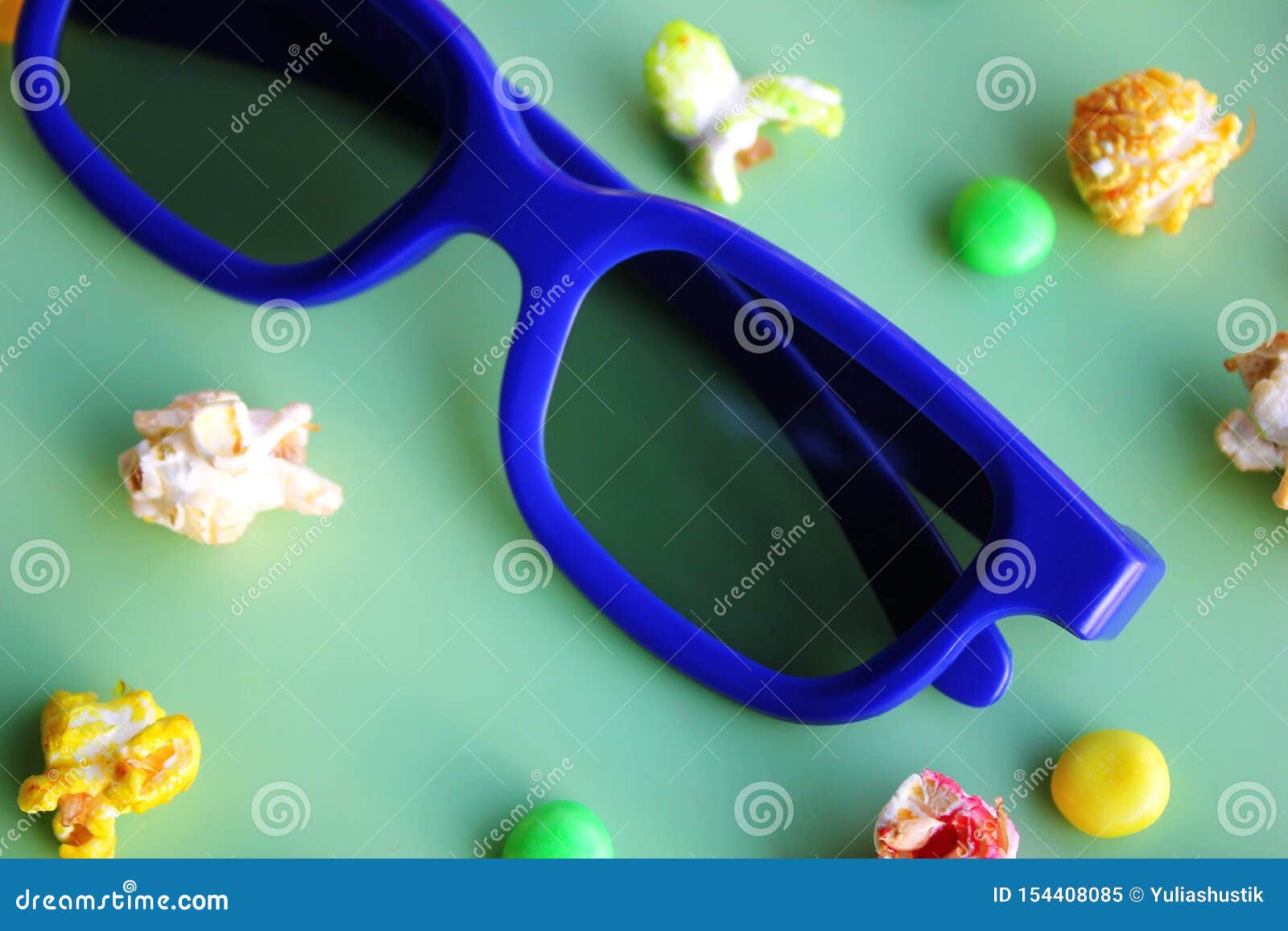 3D Glasses for Watching Movie and Colored Popcorn on Green Background