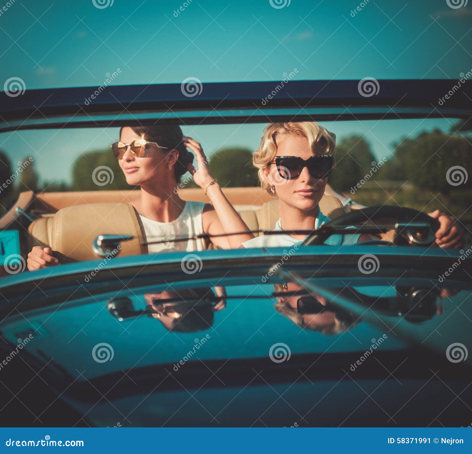 Zwei stilvolle Damen in einem klassischen Kabriolett