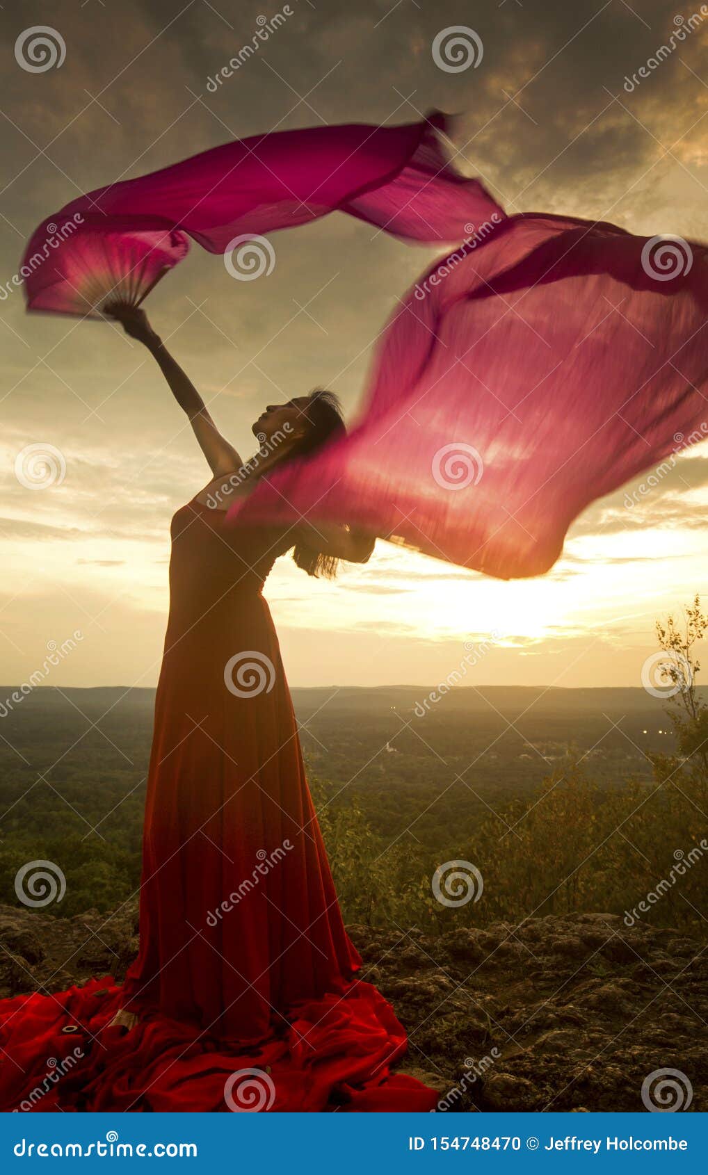 Dancer Outdoors, Twirling a Fans with Red Fabric on Them Stock Photo ...