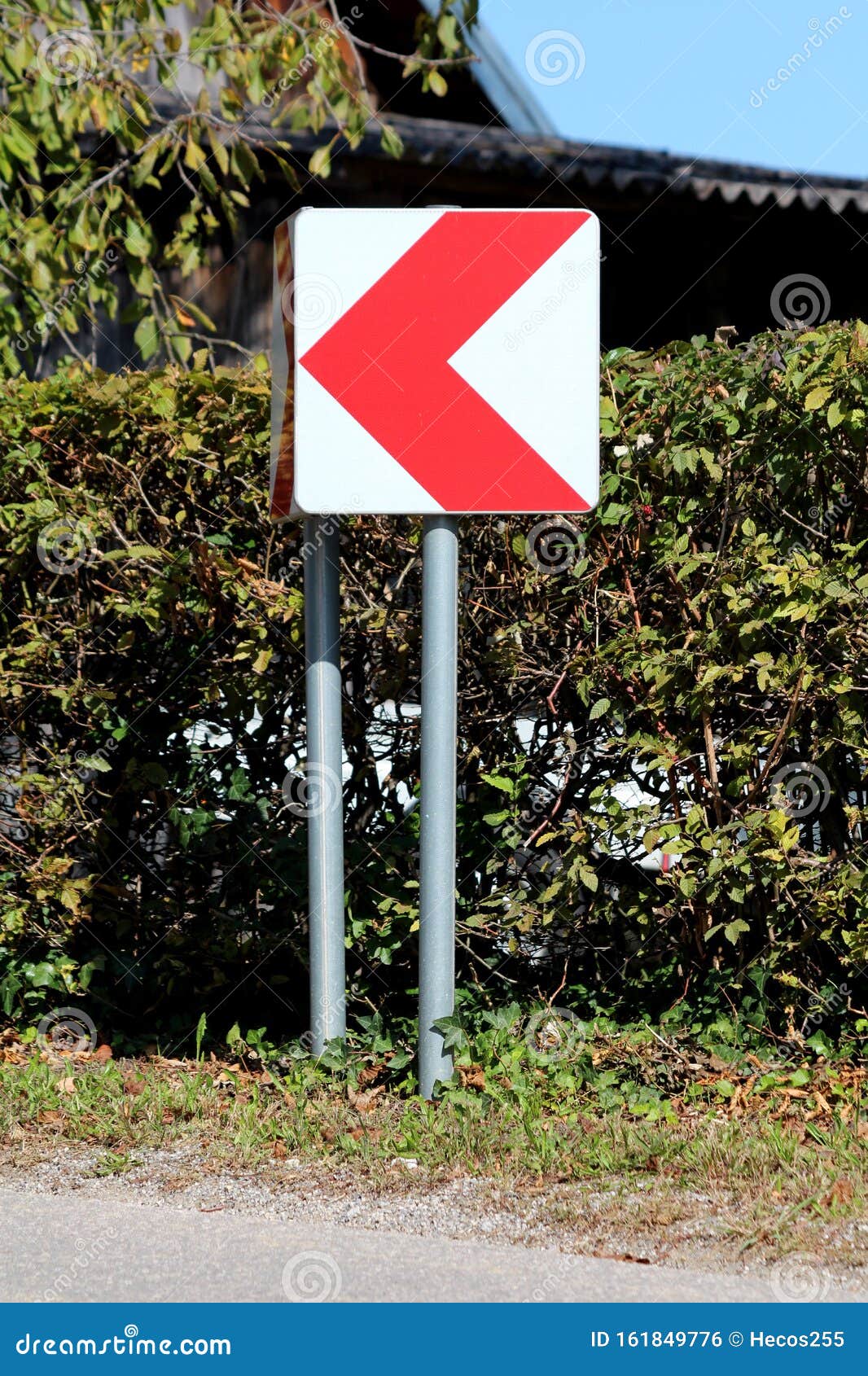 Dangerous Turn Red And White Arrow Road Sign Mounted On Metal Pole Near dangerous-turn-red-and-white-arrow-road-sign-mounted-on-metal-pole-near