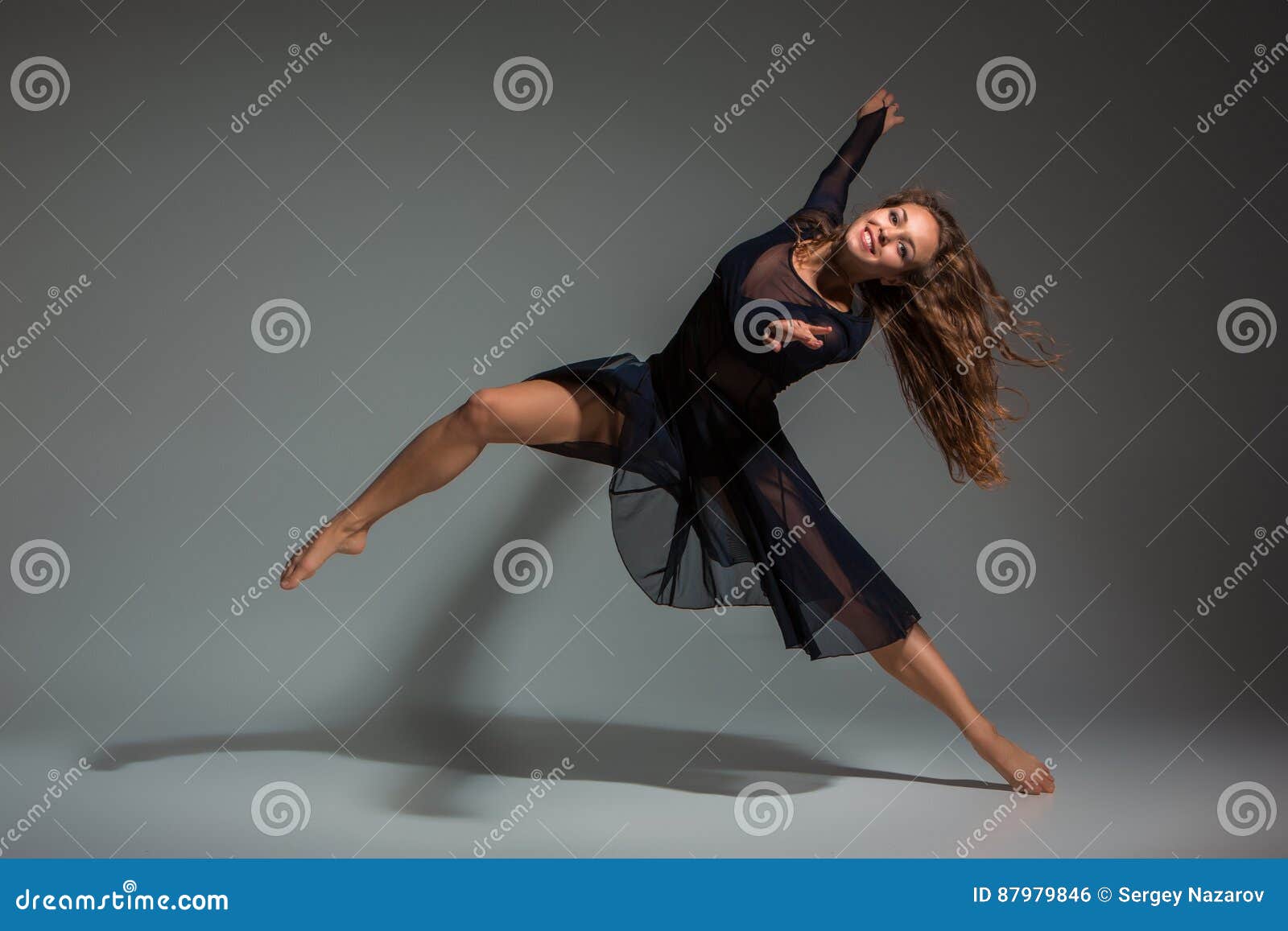 Dansende Vrouw in Een Zwarte Kleding Dans Op Een Grijze Achtergrond Stock Foto - Image of dame, dynamisch:
